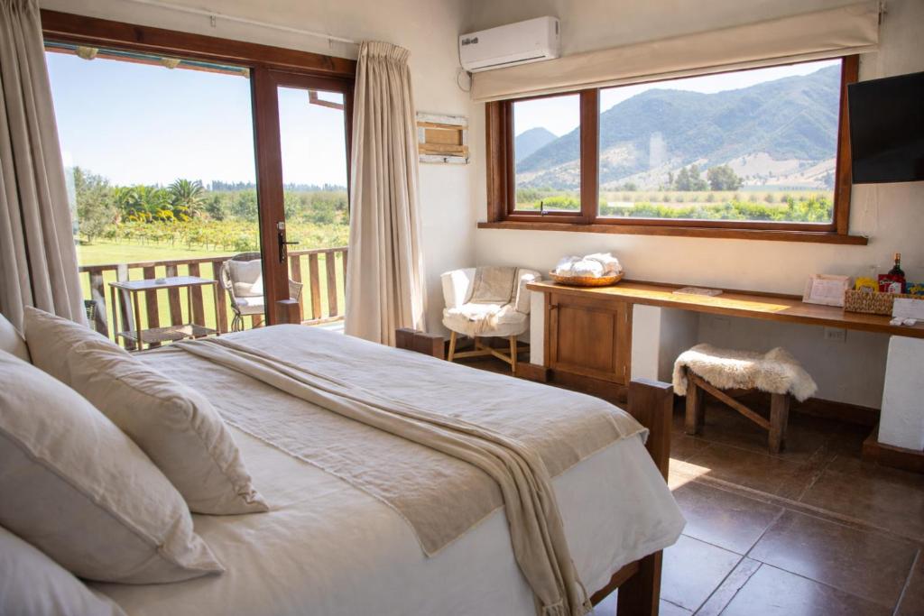 a bedroom with a bed and a desk and a window at Hotel Casa De Campo in Santa Cruz