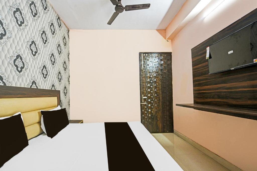 a bedroom with a bed and a television in a room at Hotel O Gulabi Delight in Faridabad