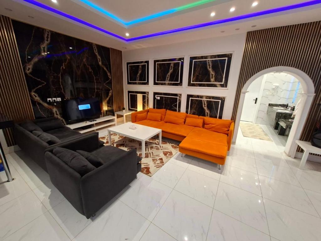 a living room with an orange couch and a table at جنة الطائف in Taif