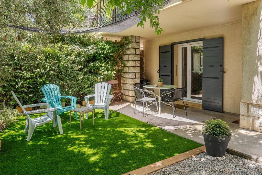 a patio with chairs and a table in a yard at La Soleillade in Manosque