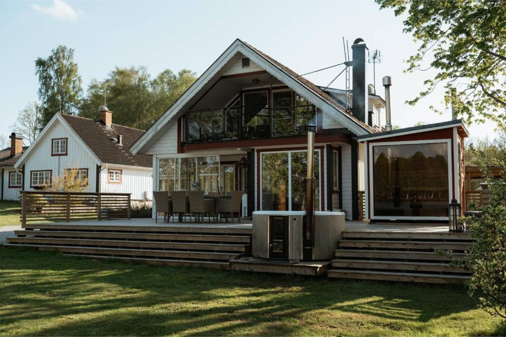 a house with a large deck with a porch at Villa Seeblick in Vissefjärda