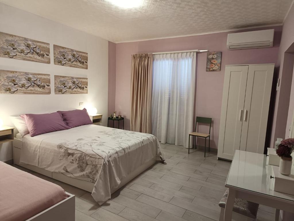 a bedroom with a bed and a table and a window at Il sentiero delle fate in Caserta