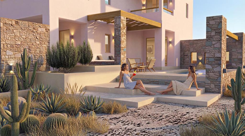 two women sitting on a couch in front of a house at Malie Suites in Mikri Vigla