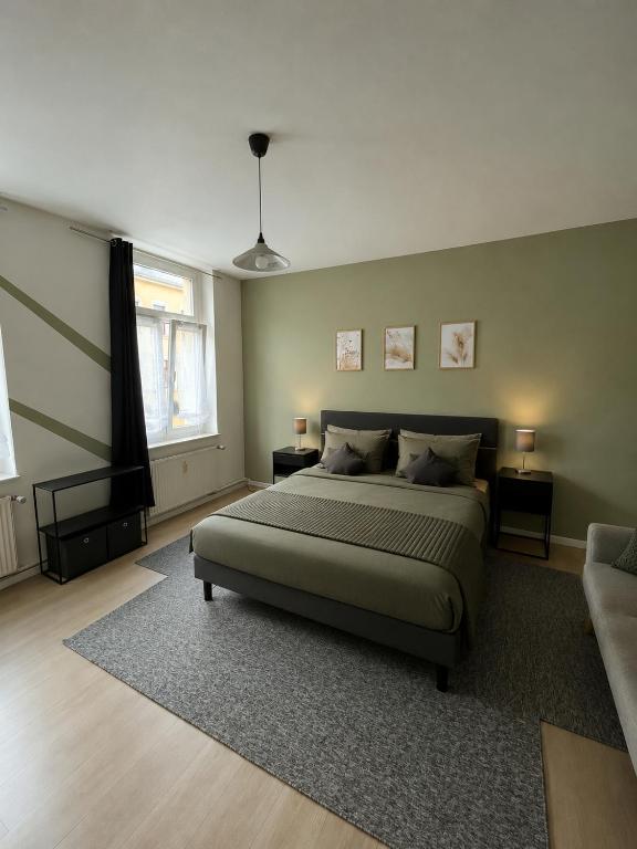 a bedroom with a large bed and a couch at Adam's Sonnenberg Apartment in Chemnitz