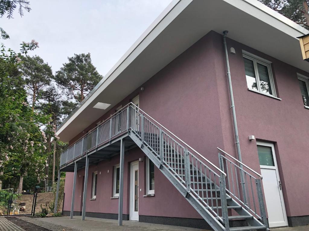 a pink building with a staircase on the side of it at Ferienwohnung26 in Blankenfelde