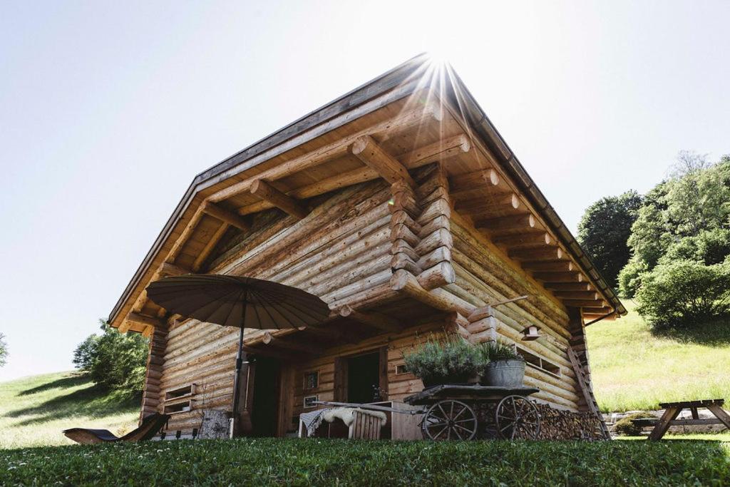 a log cabin with an umbrella in front of it at Maiensäss, Berghütte Chlara - autark, voll ausgestattet, Ressourcen begrenzt in Untervaz