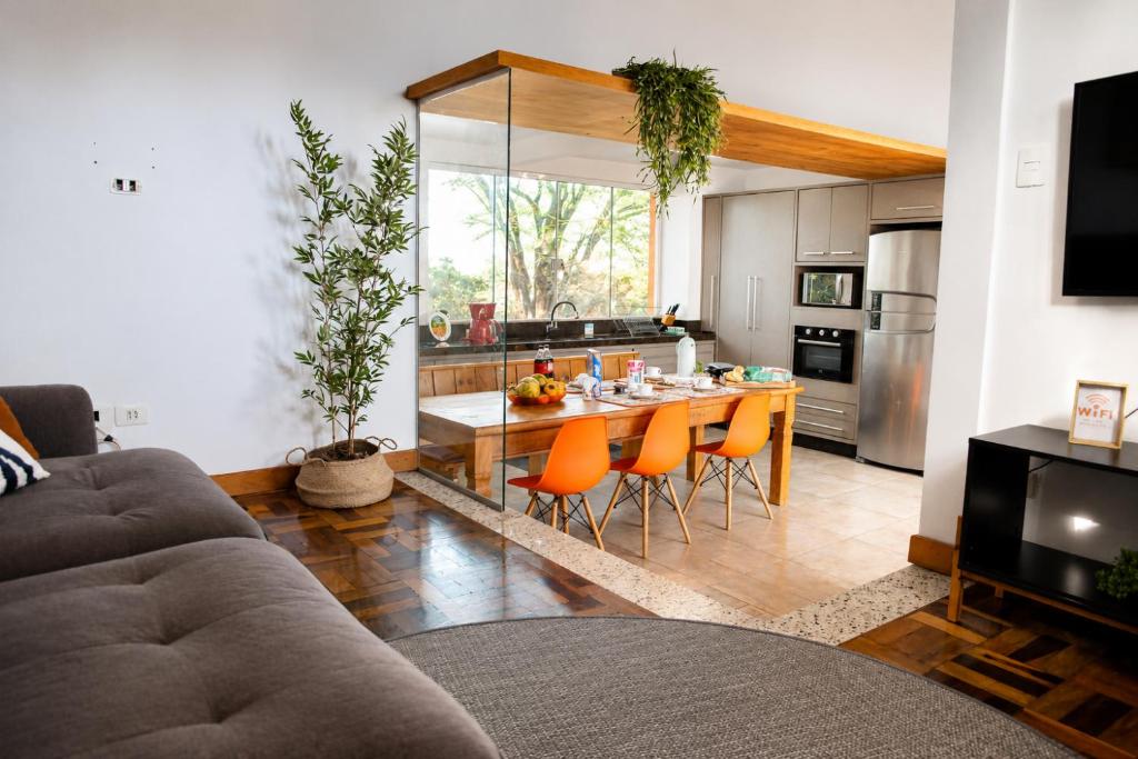 a kitchen with a table with orange chairs in it at Bem-estar e boa localização (Apto Paraíso) in Maringá