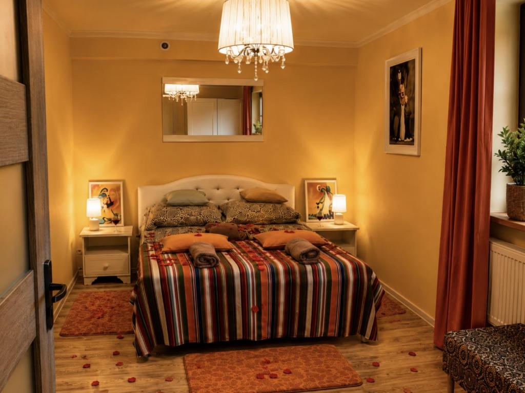 a bedroom with a bed and a chandelier at Apartament Biała Flaga Podwórko, Grill, Rowery in Charzykowy