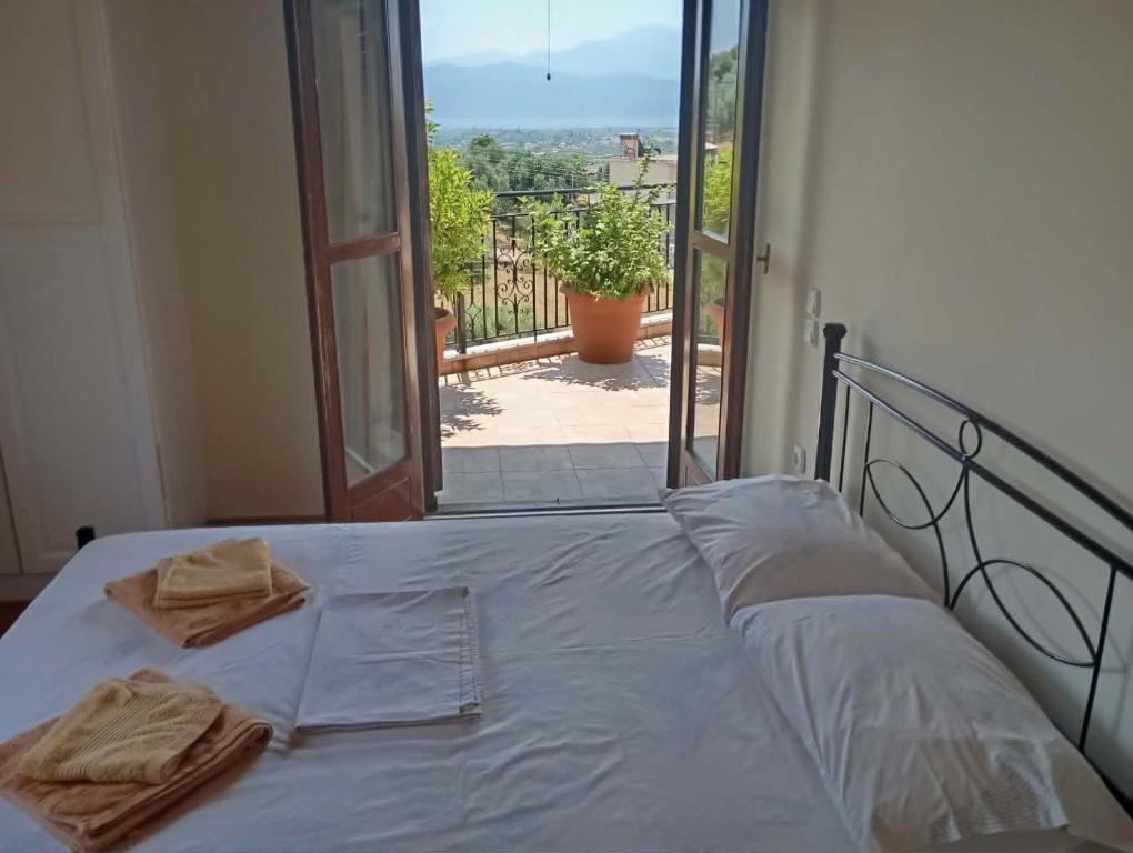 a bed with towels on it in front of a window at villa vitta - bellissimo villagio in Kastrákion