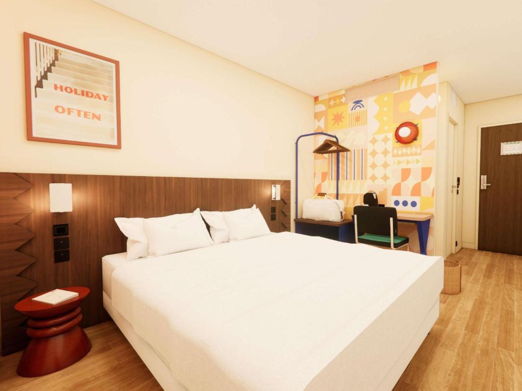 a bedroom with a large white bed and a desk at ibis Styles Lyon Gerland in Lyon