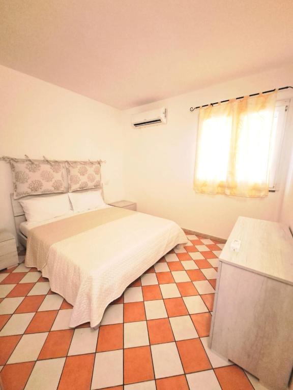 a bedroom with a bed and a checkered floor at Casa di Agnese in Alghero