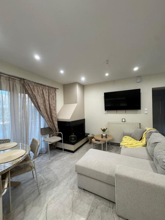 a living room with a couch and a flat screen tv at Pramanta Nest in Pramanta