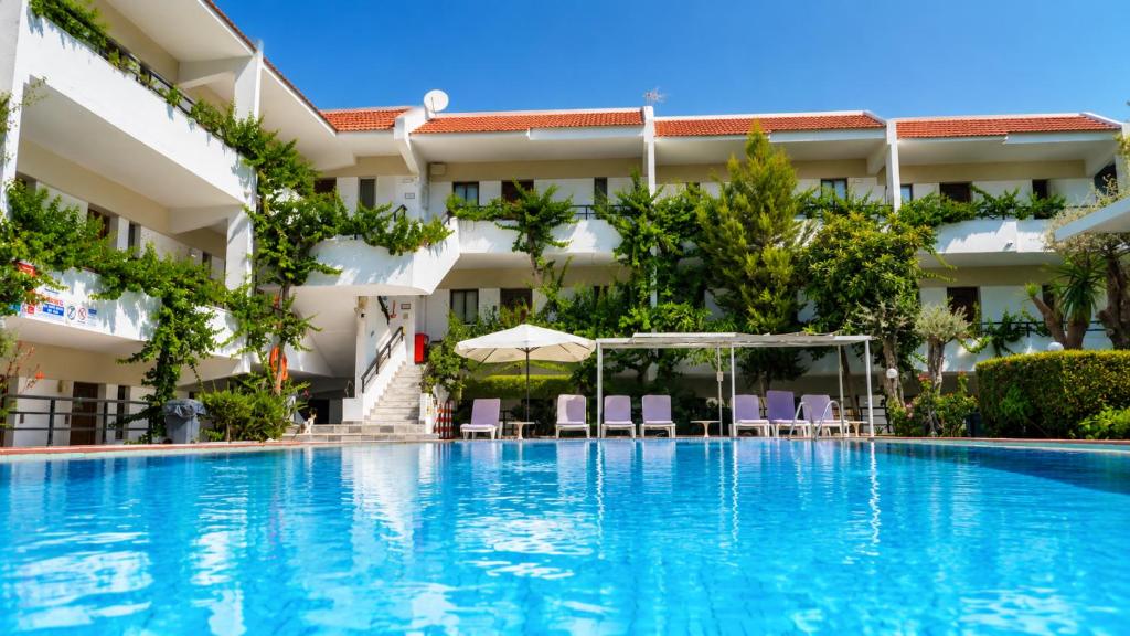 a large swimming pool in front of a building at Terinikos Sunny Garden Hotel & Junior Suites in Ialysos