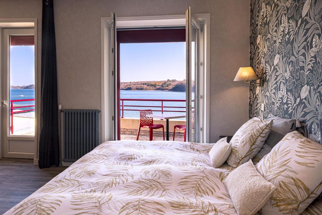 a bedroom with a bed and a view of the water at Hostellerie De La Mer in Crozon