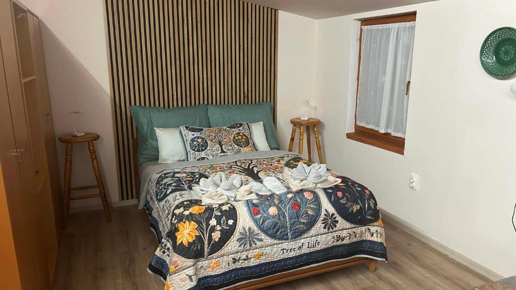 a bedroom with a bed with a comforter and pillows at Nyárfa Vendégház in Debrecen