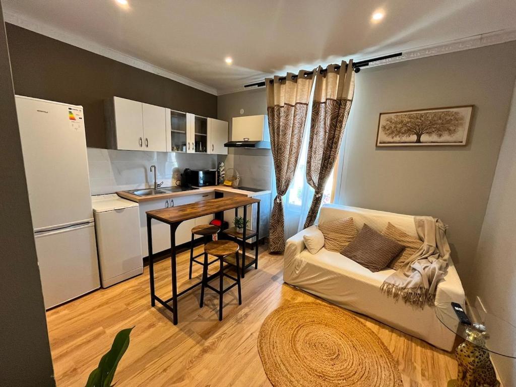 a living room with a couch and a table and a kitchen at Refuge champêtre in Champagnole