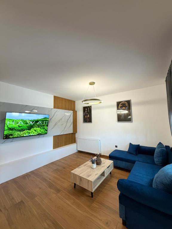a living room with a blue couch and a tv at Diktamo Village House in Ofrínion