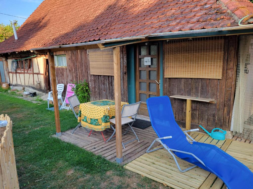 a deck with a table and chairs and a slide at Le nid de la mare in Mervans