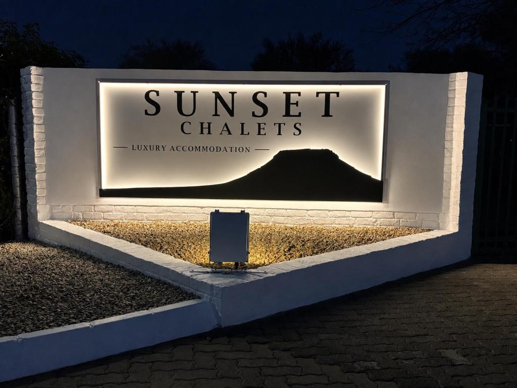 a sign for sunset chalets at night at Sunset Chalets in Colesberg