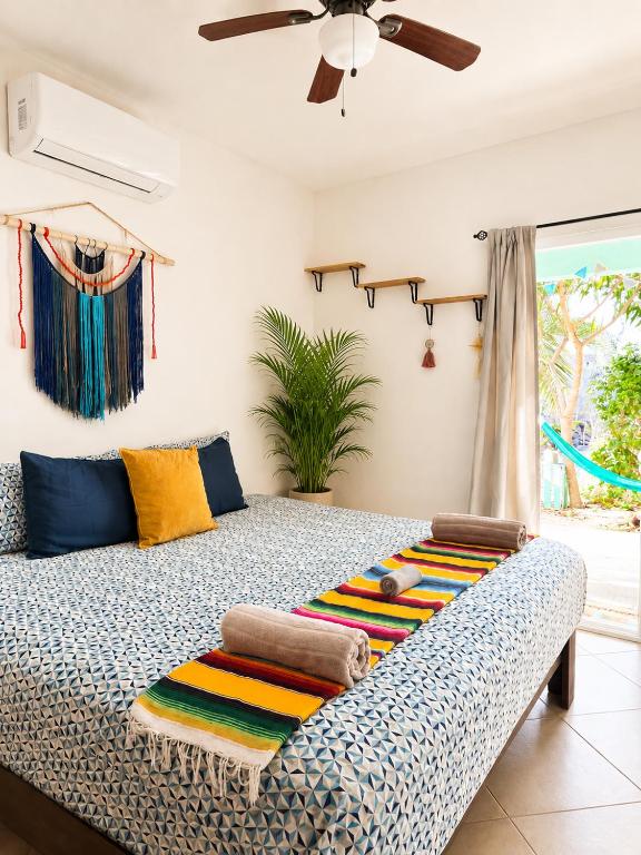 a bedroom with a bed with a ceiling fan at Garden House 2 bikes included in Mahahual