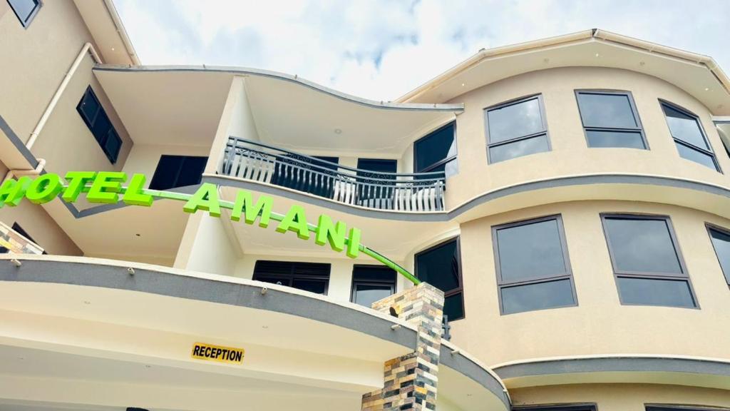 a large white building with a sign on it at Hotel Amani Limited in Mwana Island