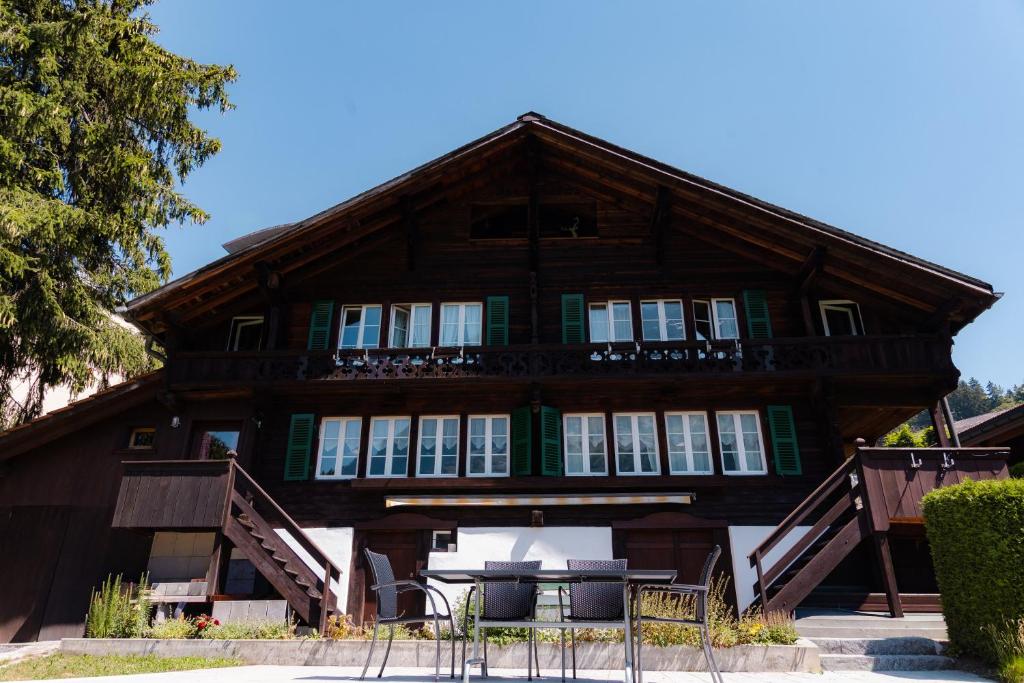 a large wooden house with a table in front of it at Cosy Swiss Apartment in Grindelwald