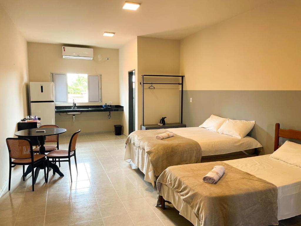 a hotel room with two beds and a table at Hospedaria Terra da Opala in Pedro II