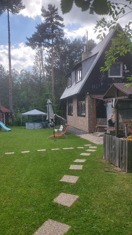 a house with a green yard withestones in the grass at Chata Strbianka in Tatranska Strba