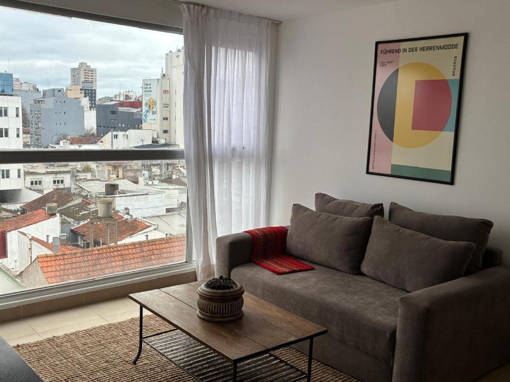 a living room with a couch and a large window at Ventanas A LA CIUDAD in Mar del Plata