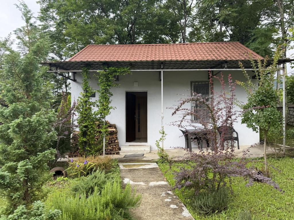 a small white house with a red roof at Okatse Lodge in Gordi