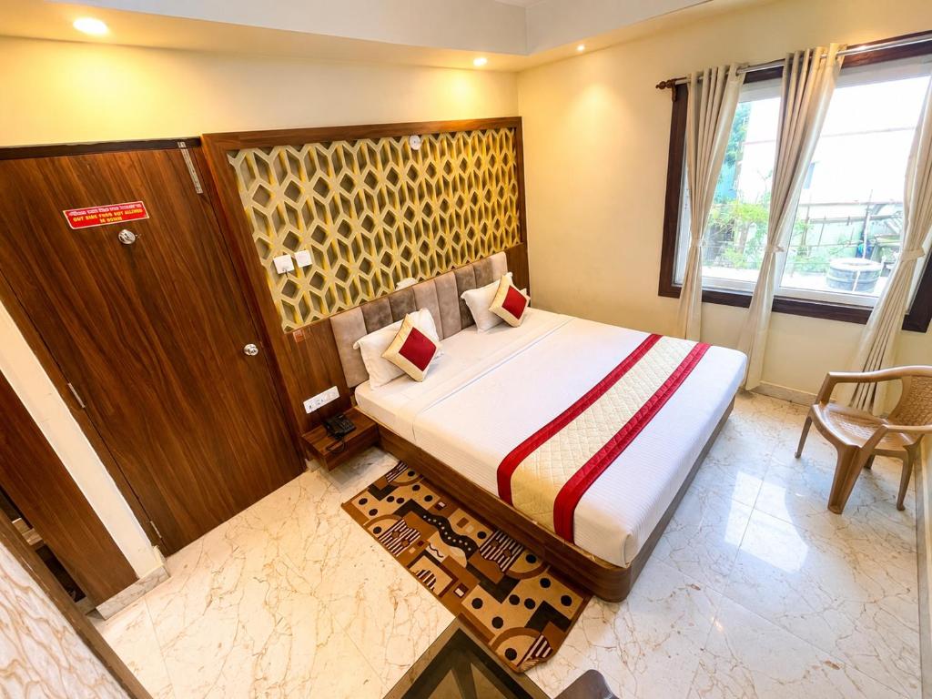a hotel room with a bed and a chair in it at SEA BEACH HOTEL Near Swargadwar-Golden Beach- Jagannath Temple - PARK , Fully Air Conditioned Rooms ,Wifi , Lift , And Free Parking , BEST HOTEL IN PURI in Puri
