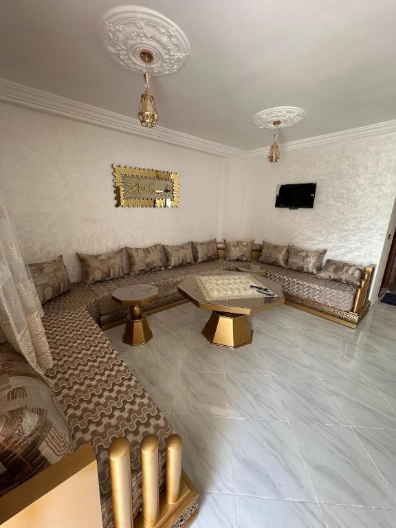 a living room with a couch and a table at Mini Villa Acote de Plage Rhach in Dar Bou Halouf