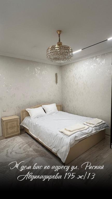 a bedroom with a bed and a chandelier at Royal hostel in Osh