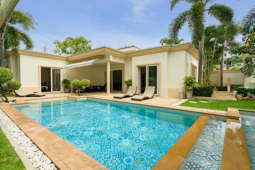 a swimming pool in front of a house at Luxury Pool Villa 3BR 6-8 persons in Nong Prue