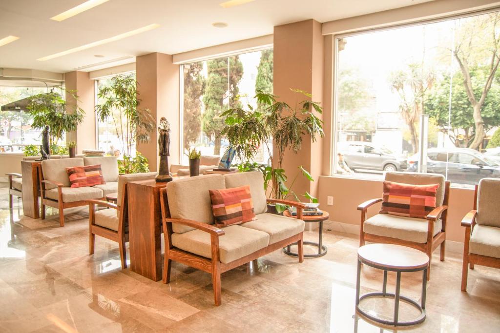 A broad hotel waiting area with street-facing windows and upholstered seating.