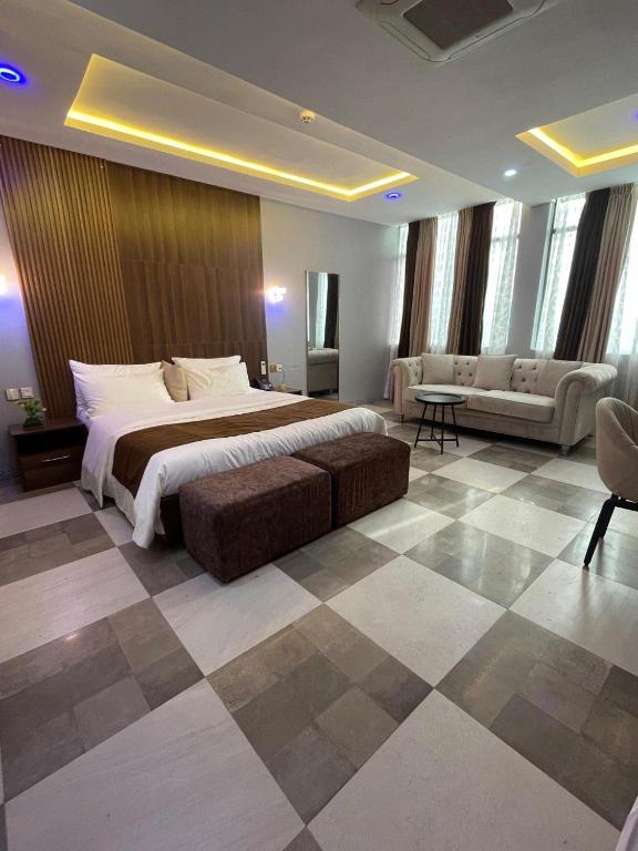 a bedroom with a bed and a couch in a room at Andysilk Resort International in Ozu Abam