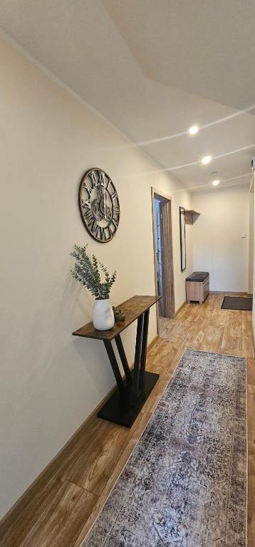 a room with a table and a clock on the wall at Apartament 5- Bliżej Zdroju in Polanica-Zdrój