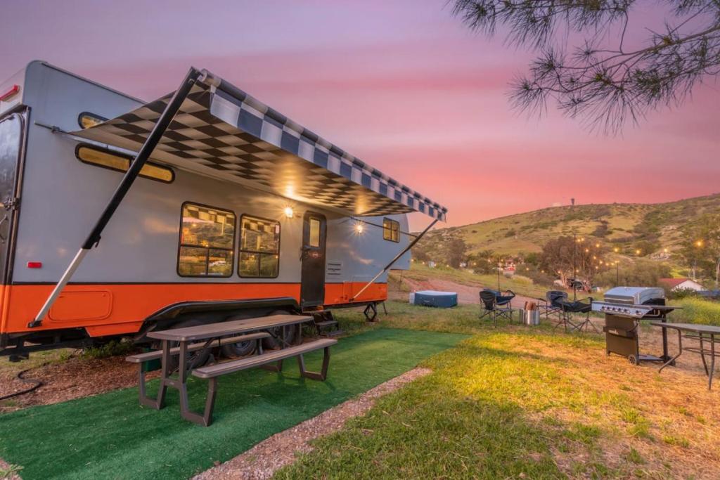 a caravan parked in a field with a picnic table at Harley Davidson Ranch Glampling With Kids Play Zone in Ramona
