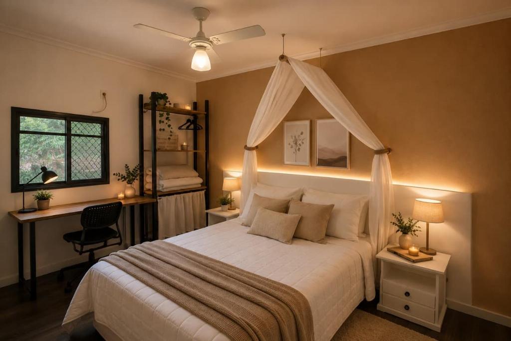a bedroom with a bed and a desk and a window at Hotel Casa Encantada in Penedo