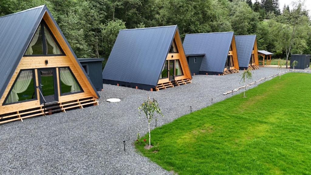 a row of lodges lined up in a field of grass at Complex turistic Casa Diaconu in Breaza