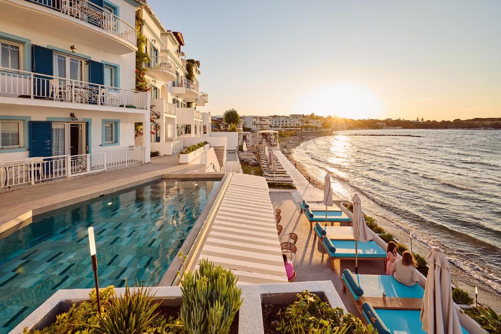 a swimming pool in front of a building next to the water at Filoxenia Beach in Tsilivi