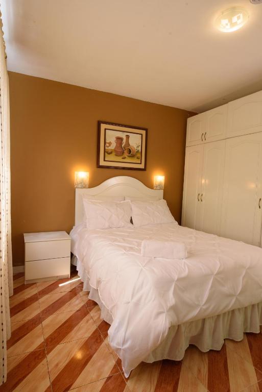a bedroom with a large bed with white sheets at Casa Elalu in Quito