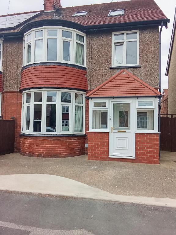 a red brick house with a white door at Flown The Nest in Bridlington
