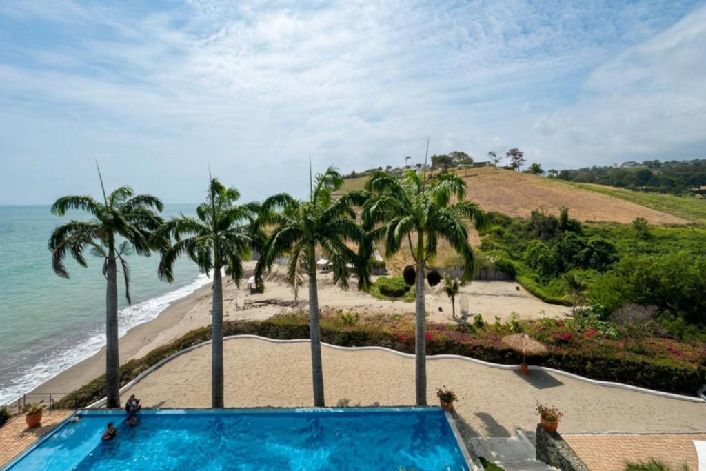 a swimming pool next to a beach with palm trees at Jama Campay Hotel by Otium in Los Camarones