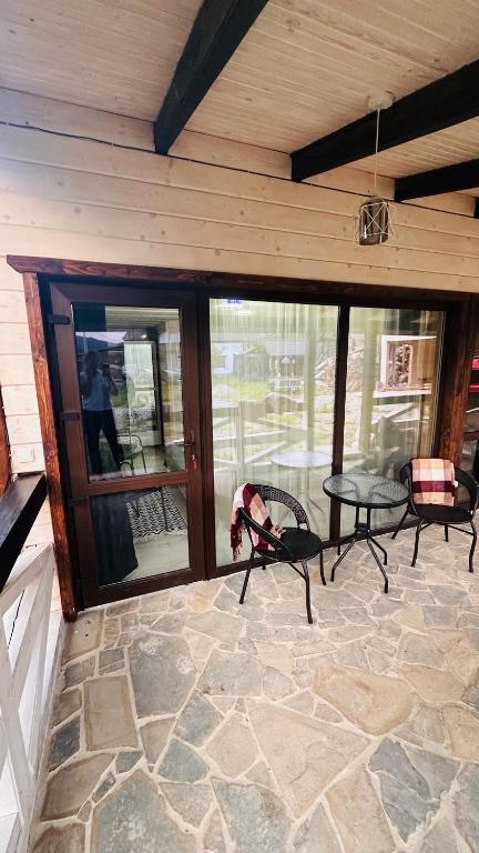 a screened in porch with a table and chairs at Едем 2 in Verkhovyna