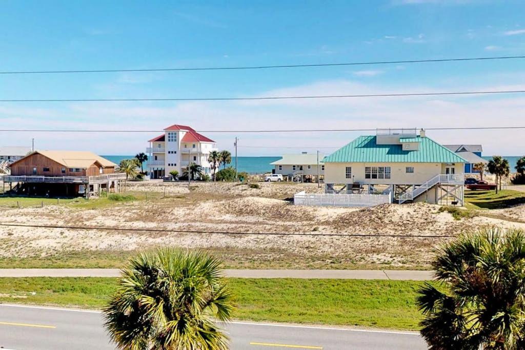 a house on a hill with palm trees and a road at Charming ocean-view gem with a pool deck washer dryer & central AC in St. George Island
