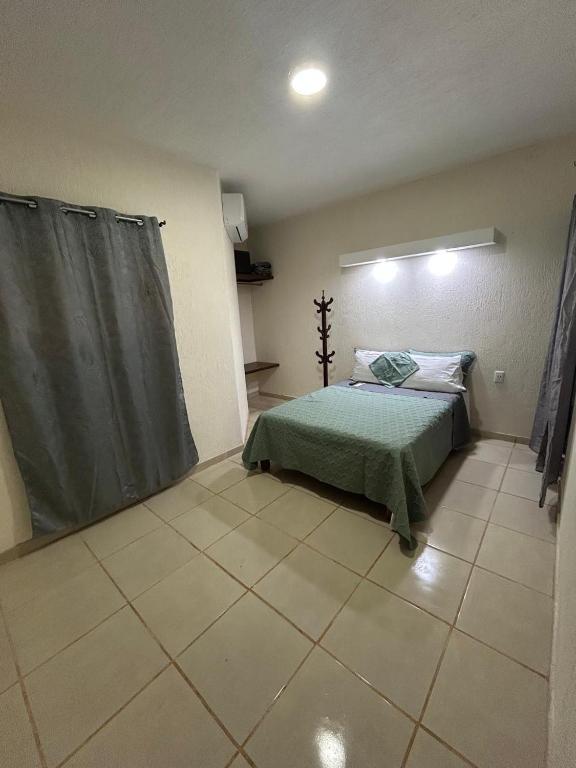 a bedroom with a bed and a tiled floor at Departamento Rousse in Tequila