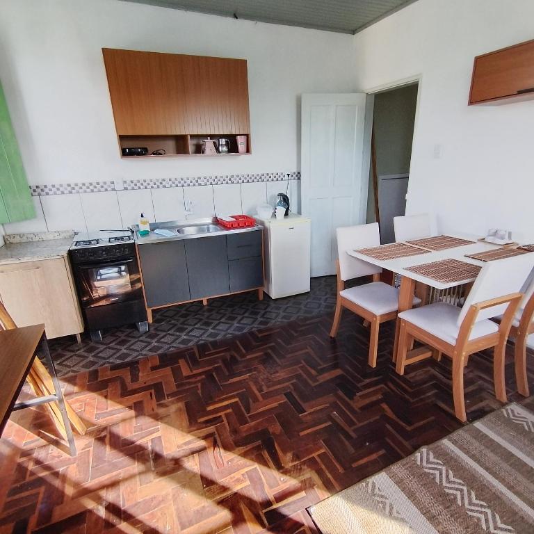 a kitchen with a table and a white refrigerator at Sobrado de esquina in Pelotas
