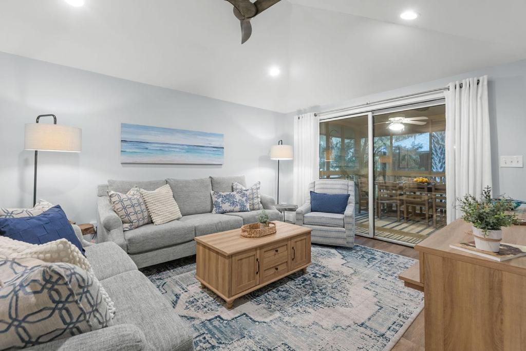 a living room with a couch and a table at 1128 Summerwind Cottage in Seabrook Island
