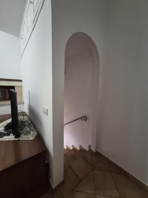 a hallway with an archway in a white wall at La casina dei nonni in Sinalunga